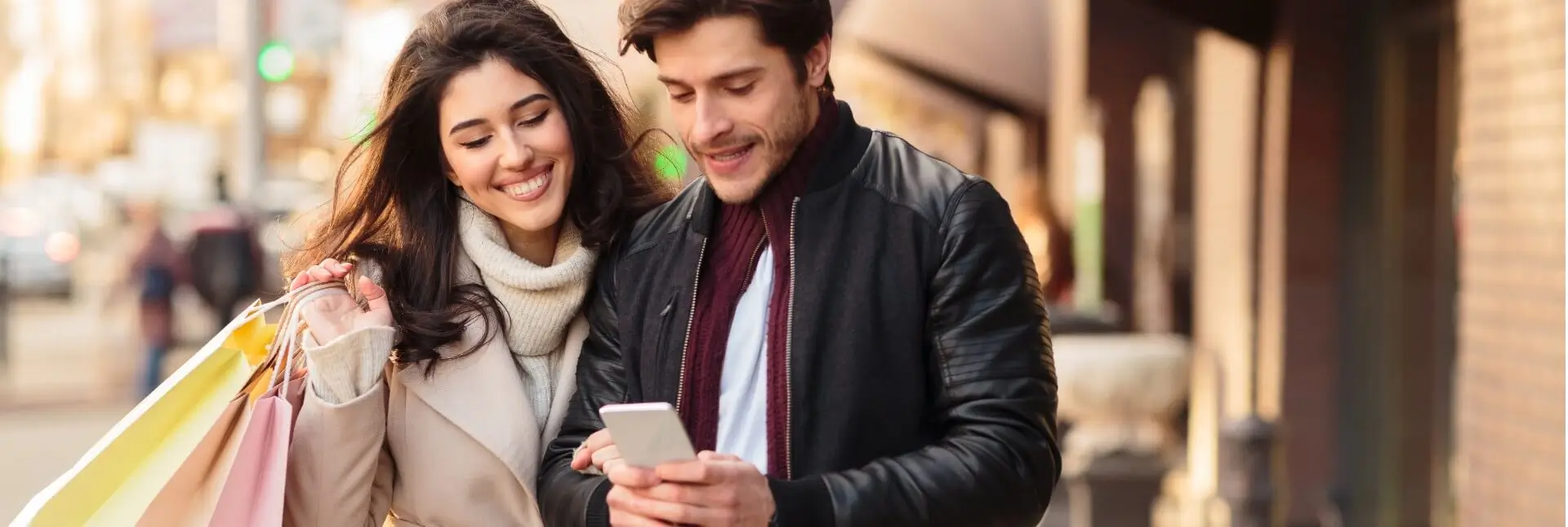 Smiling couple walking outdoors while shopping